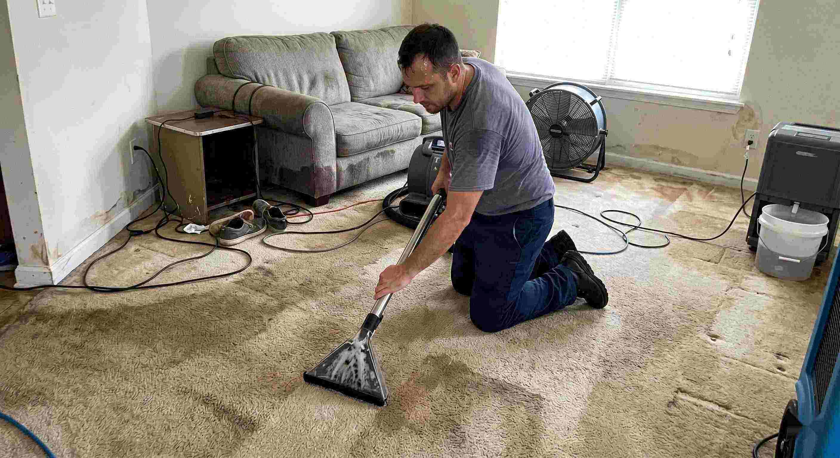 Technician performing carpet water extraction in a residential home using professional equipment after water damage in Reno
